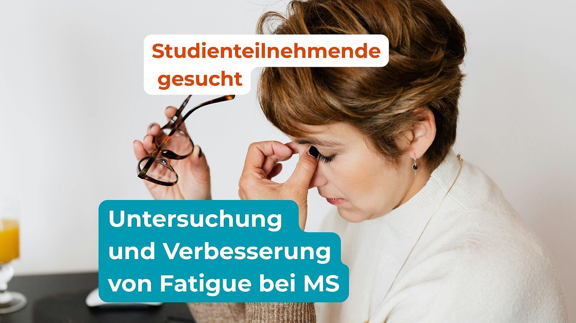 Eine Frau sitzt am Schreibtisch und reibt sich die Augen.